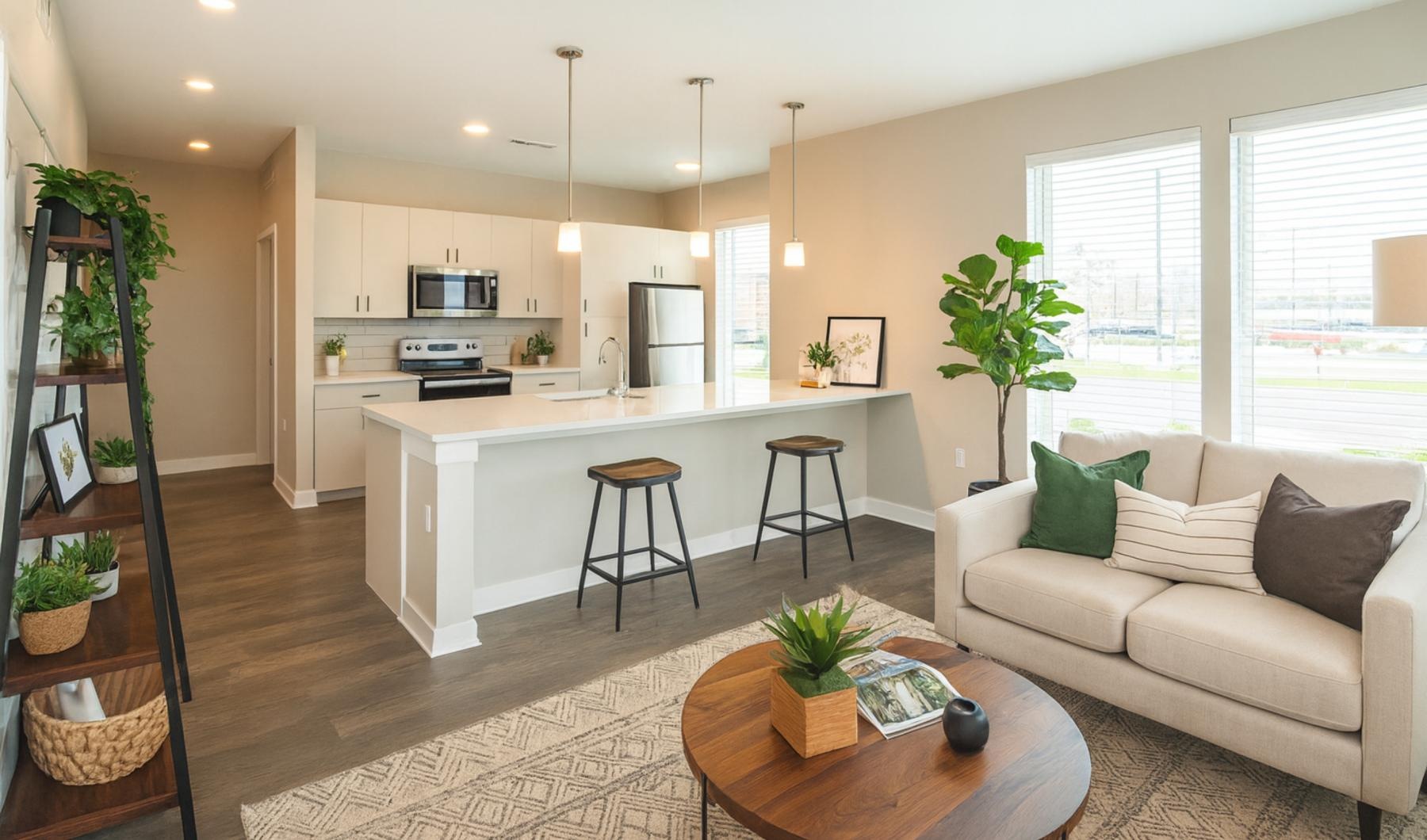 Beautiful living spaces with natural lighting a living room with a kitchen island beyond