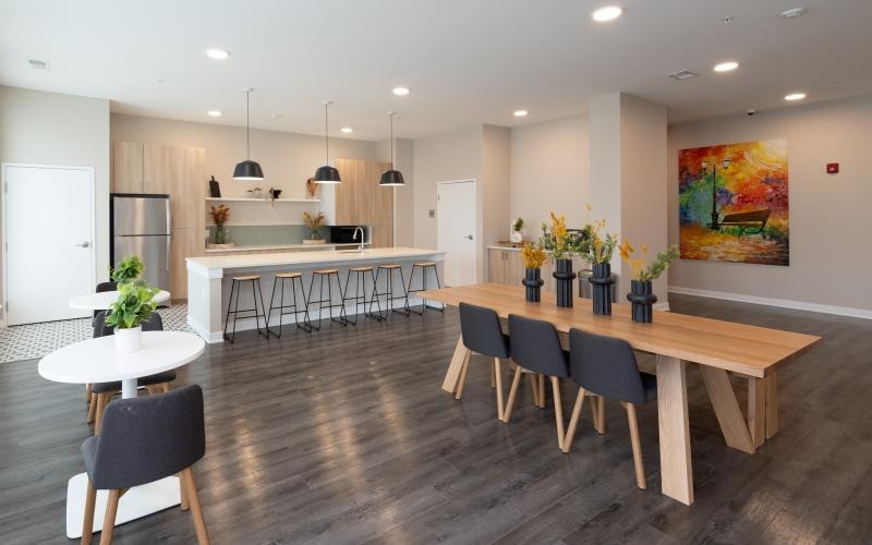 a large room with a dining table and bar and chairs