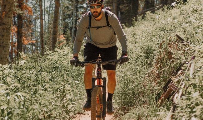 A beautiful community at the heart of all your passions man riding a bike on a trail in the woods